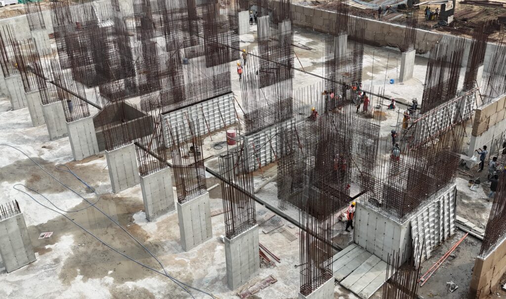 Concrete columns and walls with exposed reinforcement bars on site, with aluminium wall formwork panels in place