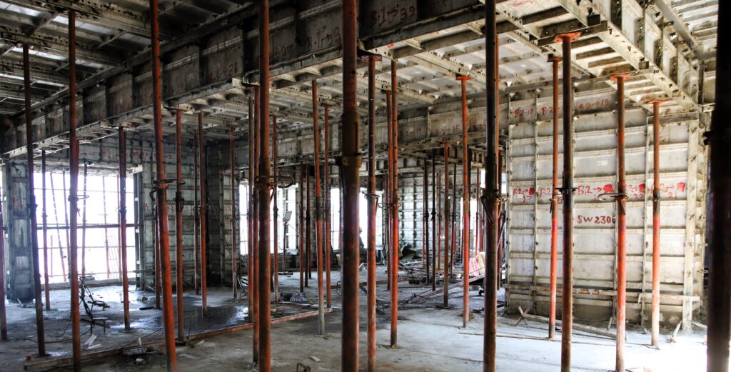 Rows of steel props supporting aluminium slab formwork inside a floor under construction